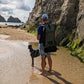 Man walking dog on beach wearing ancona backpack